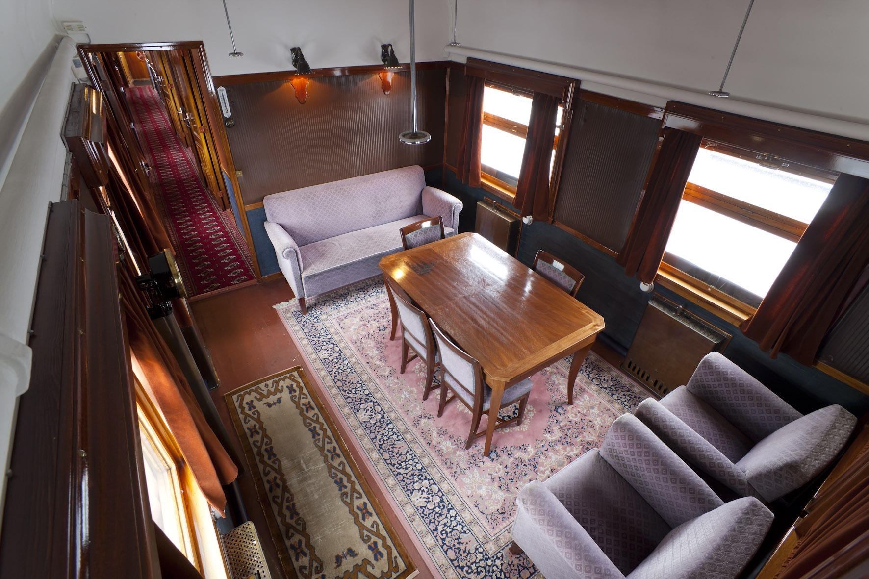 Mannerheimin salonkivaunun huone, jossa sohvaryhmä, pöytä ja tuolit sekä itämaistyylinen lattiamatto.