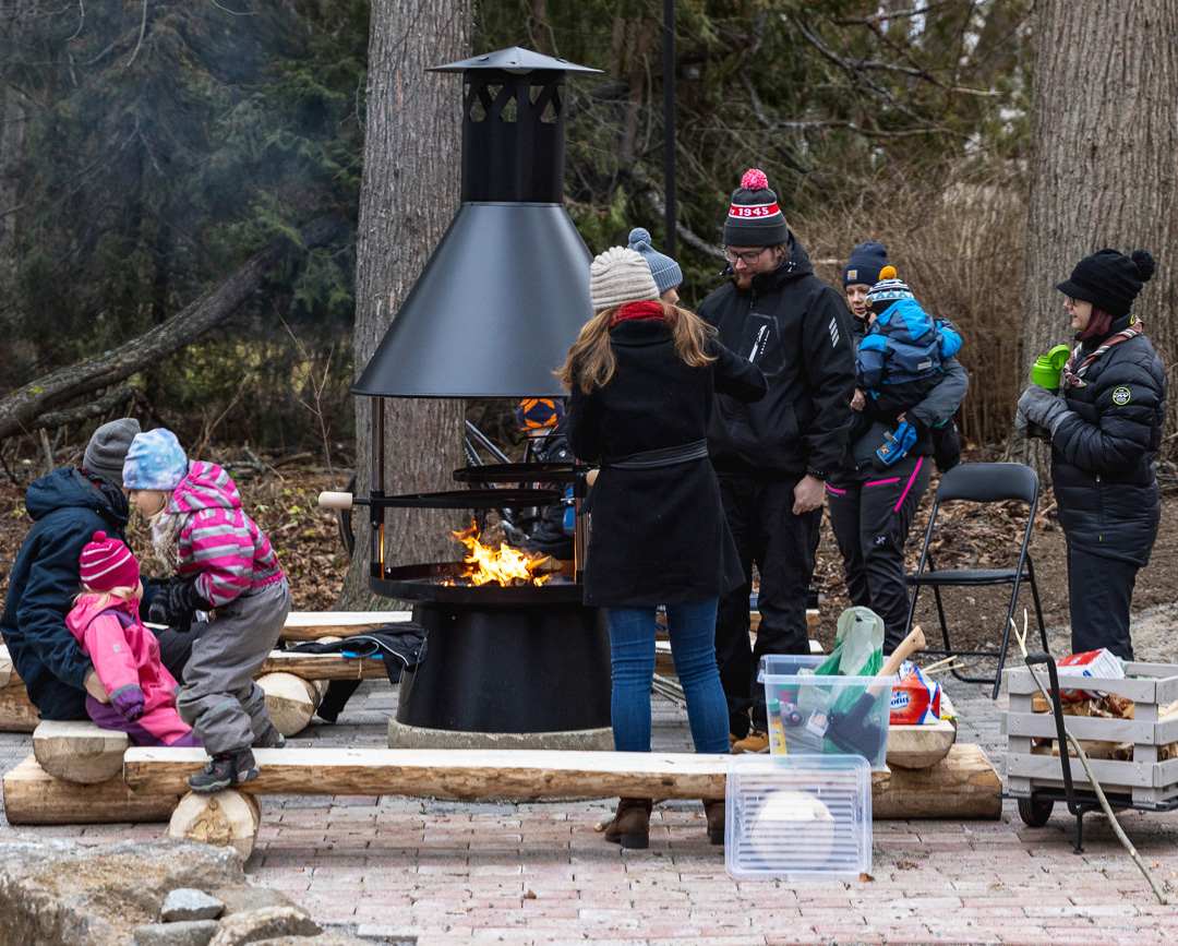 Tulipaikan äärellä aikuisia ja lapsia viettämässä evästaukoa.